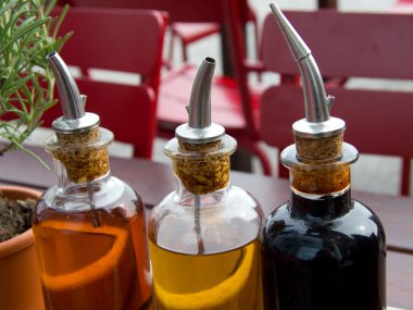 Balsamic vinegar bottles and condiments on the table in an open clipart