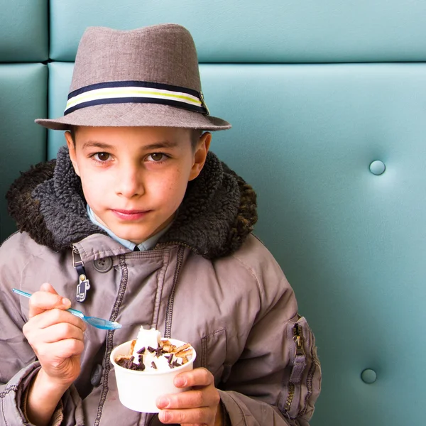 Cute teenage boy eating ice cream with chocolate topping — Stock Photo, Image