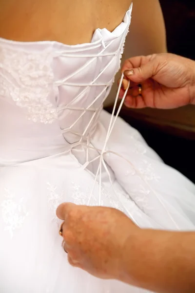 Невеста одевается в свадебное платье — стоковое фото