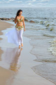 schöne junge Mädchen zu Fuß am Strand