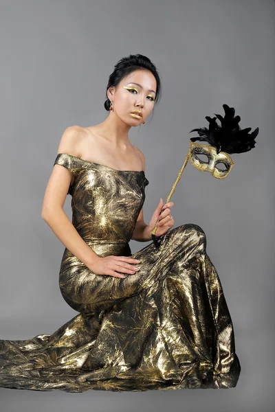 Kvinna i gyllene kvällen klänning — Stockfoto