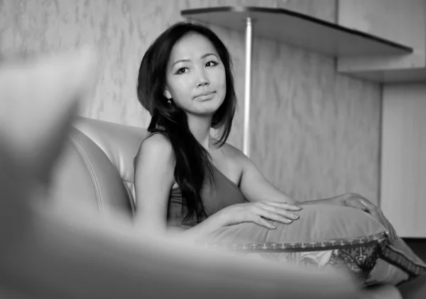 Asiatisk kvinna sitter på soffan — Stockfoto