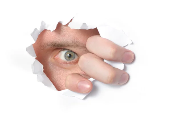 Ojo mirando a través de un agujero en papel —  Fotos de Stock