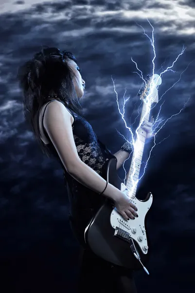 Woman rock star with guitar in hands and lightning storm — Stock Photo, Image