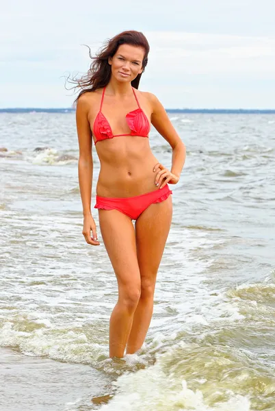 Mooie vrouw in rode bikini in water — Stockfoto