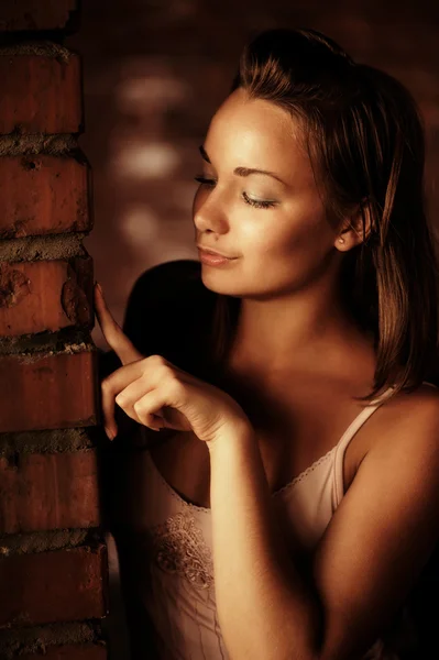 Tuğla duvarın yanında güzel bir kadın — Stok fotoğraf