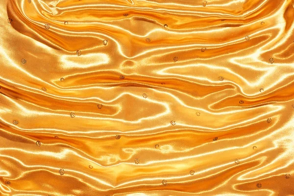 Golden textile with folds as background — Zdjęcie stockowe
