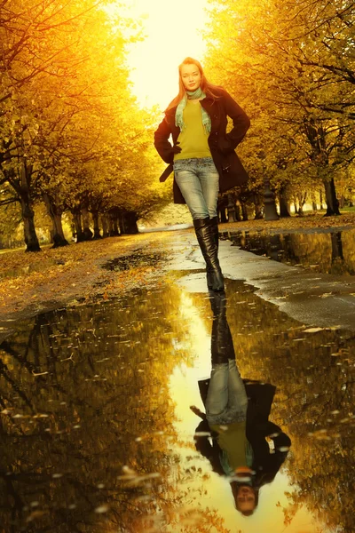 Woman at autumn outdoors walking on puddle — Stock Photo, Image