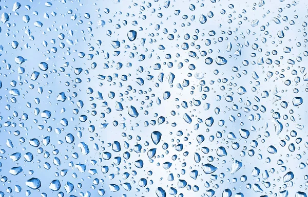 Muchas gotas de agua azul en vidrio de ventana —  Fotos de Stock