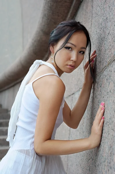 Aziatische vrouw in de buurt van muur — Stockfoto