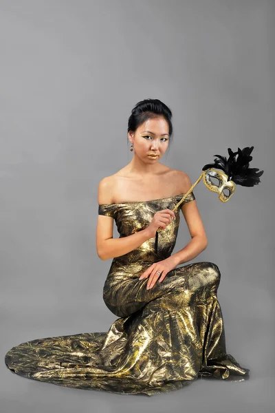 Азиатка с маской в руке — стоковое фото