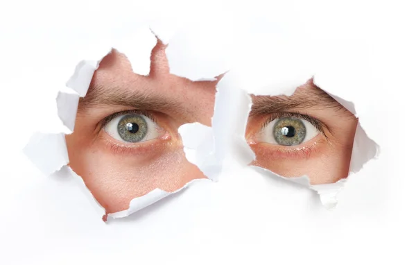 Eyes looking through a hole — Stock Photo, Image