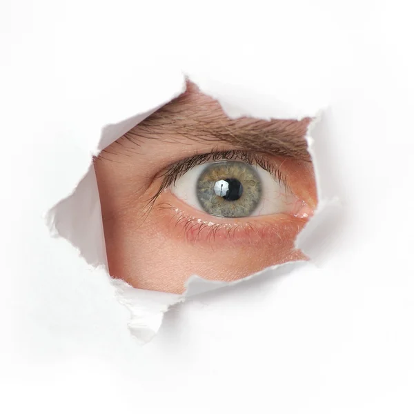 Auge blickt durch ein Loch im Papier — Stockfoto