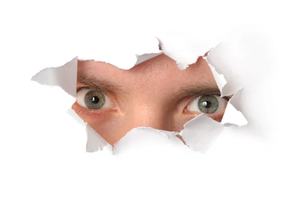 Eyes looking through a hole in paper — Stock Photo, Image