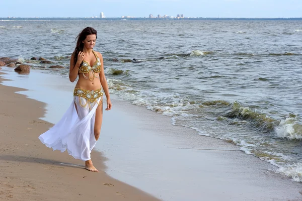 Beautiful young girl walking on beach — Stock Photo, Image