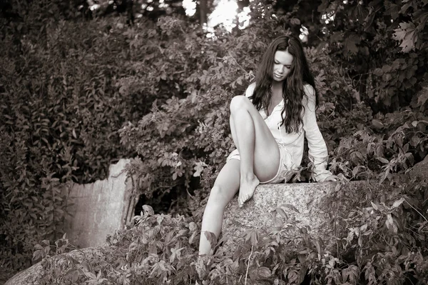 Femme assise sur des pierres — Photo