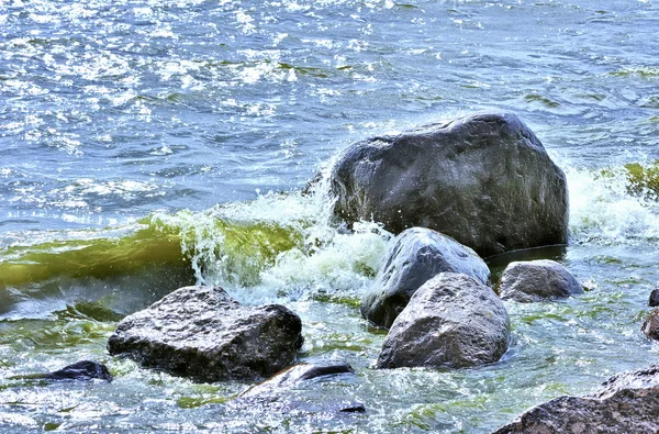 Havvann som fosser forbi en stein – stockfoto
