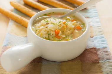 Chicken rice soup with bread stick clipart