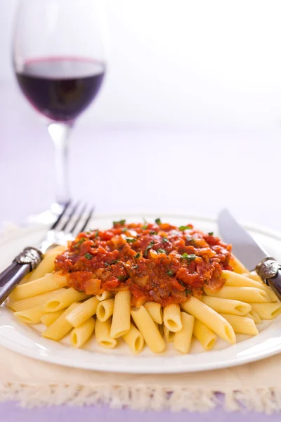 Arrabiatta-pasta og vin – stockfoto