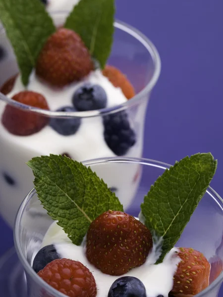 Фрукты и йогурт на голубом — стоковое фото