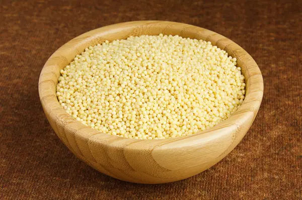 Stock image Millet in a Serving Bowl on a Brown background