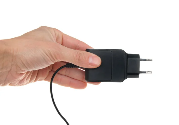 O adaptador elétrico em uma mão, isolado no branco — Fotografia de Stock