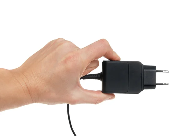 De elektrische adapter in een hand, geïsoleerd op de witte — Stockfoto