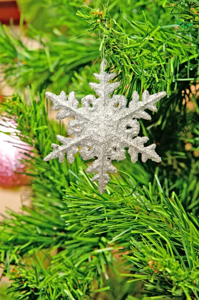 Artificial snowflake on a green fur tree — Stock Photo, Image