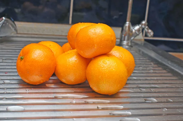 金属制厨房的表面上的橘子 — 图库照片