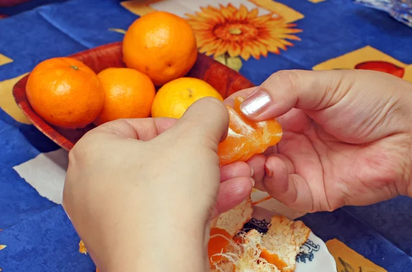 kadın mavi bir bez üzerine mandalina temizler