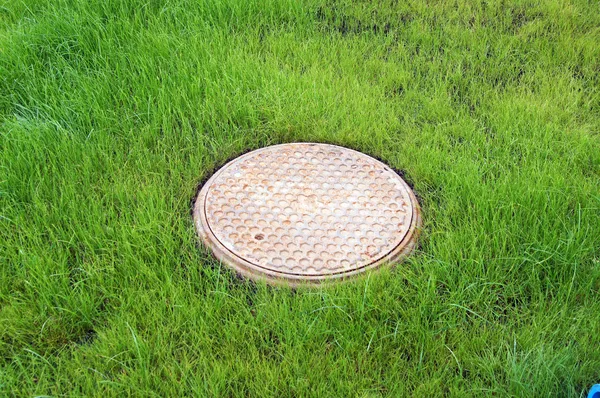 Kanalizacja na zielony trawnik — Zdjęcie stockowe