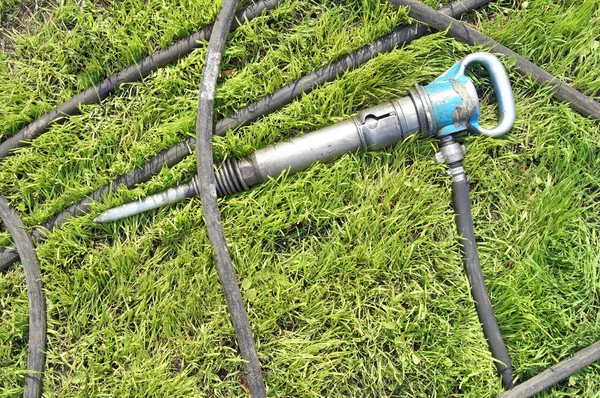 Presslufthammer auf dem grünen Rasen — Stockfoto