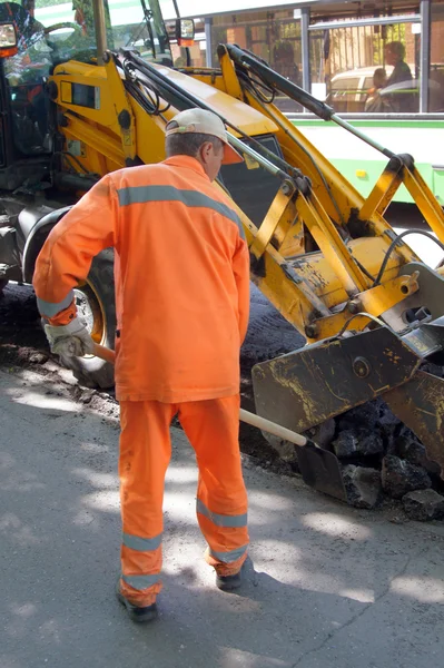 The worker shifts a shovel asphalt — Stock Photo, Image