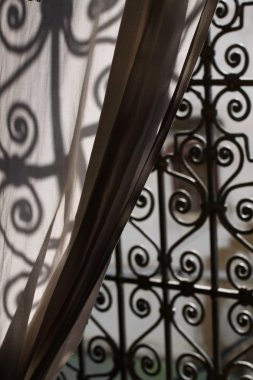 An elegant iron window in a Moroccan Market draped by a Curtain clipart