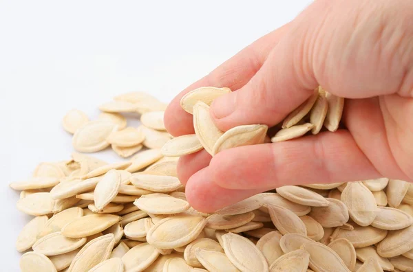 stock image Pumpkin seeds in hand on white background