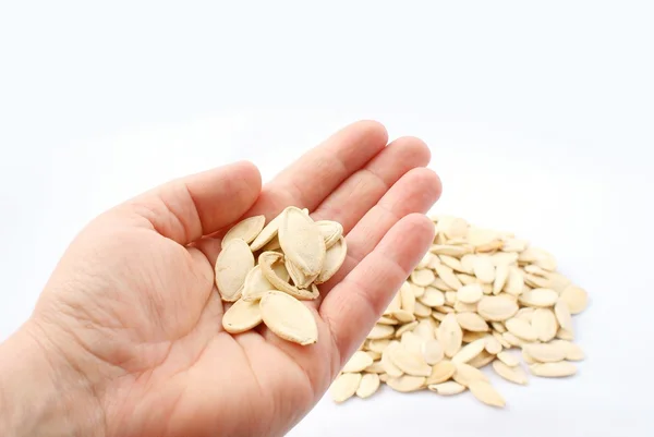 Pumpkin seeds in hand on white background — Stock Photo, Image