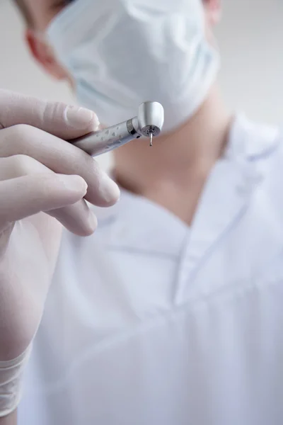 stock image Hands of dentist holding dril.