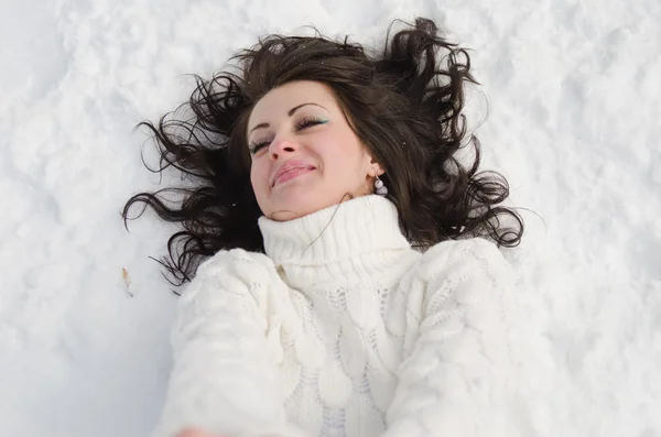 Pretty woman lying on snow. — Stock Photo, Image