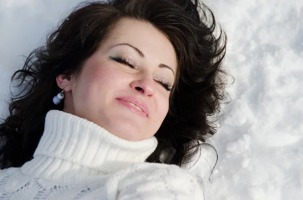 Pretty woman lying on snow. — Stock Photo, Image