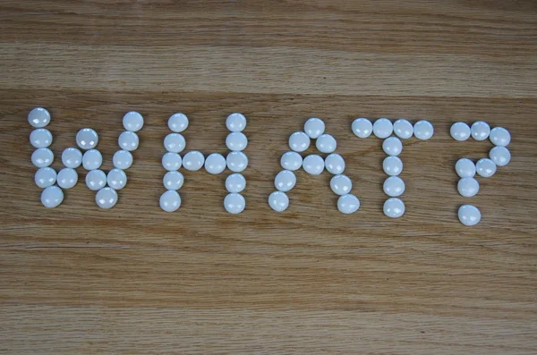 stock image The word What? written in white beads