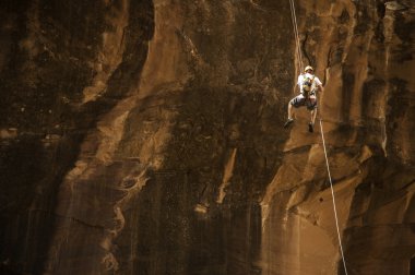 kaya tırmanışçısı rapelling turuncu uçurumdan aşağı