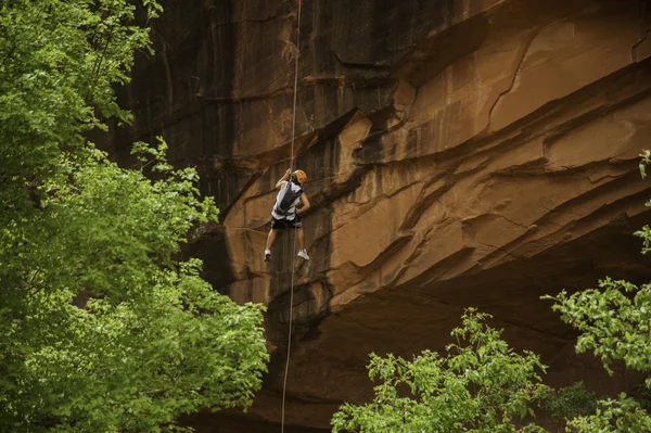 オレンジ色の崖から岩の登山家 rapelling — ストック写真