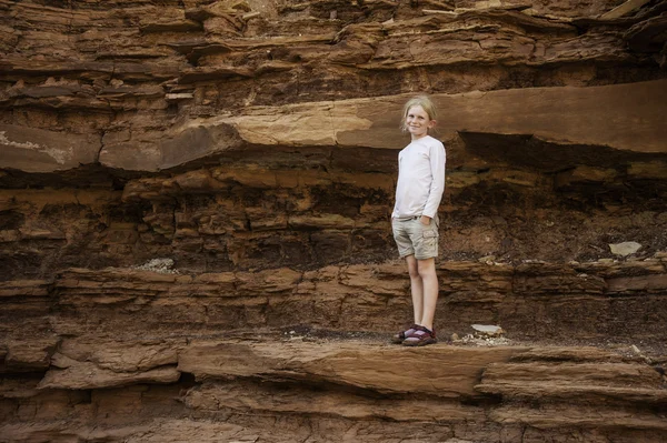 Young girl standing in desert canyon — Stock Photo, Image