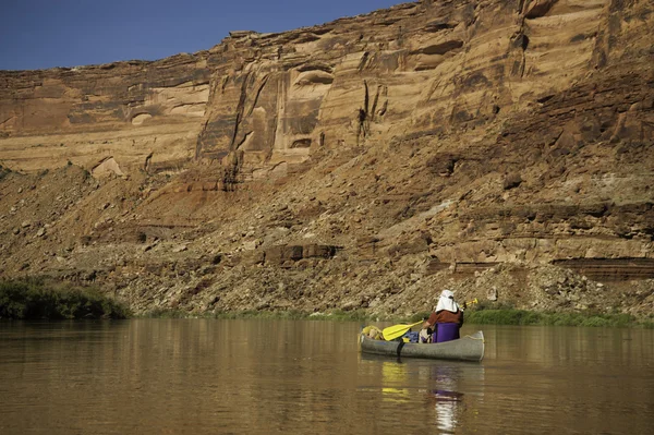 stock image Man paddling canoe in desert canyon river