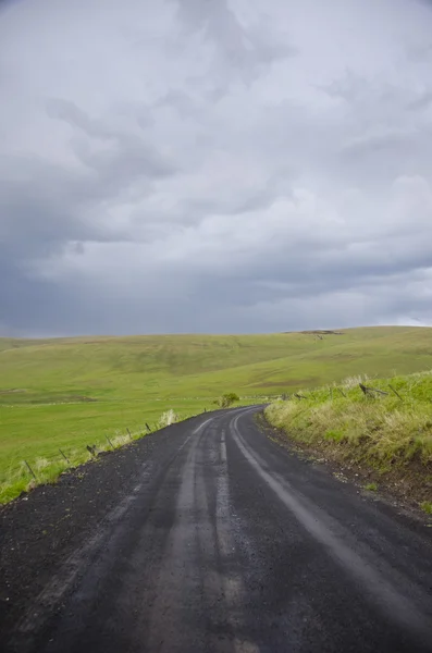 Гравийная сельская дорога под бурным небом — стоковое фото