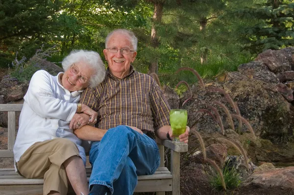 Uomo e donna anziani seduti su una panchina — Foto Stock