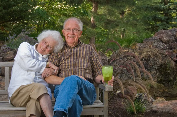 Anciano y mujer sentados en un banco Imagen de archivo