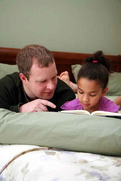 Отец читает дочери — стоковое фото
