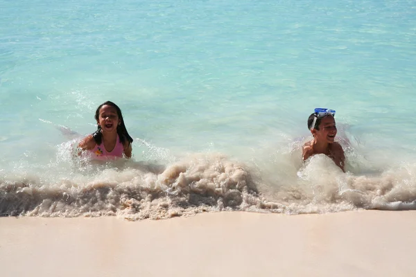 Kız ve oğlan kumsalda oynarken — Stok fotoğraf