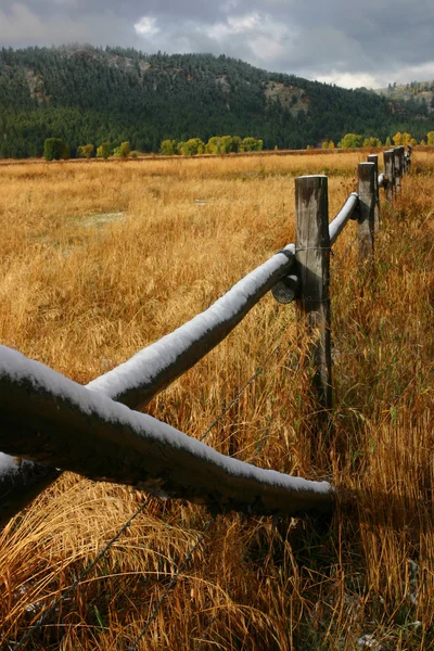 Деревянный забор рядом с горами — стоковое фото